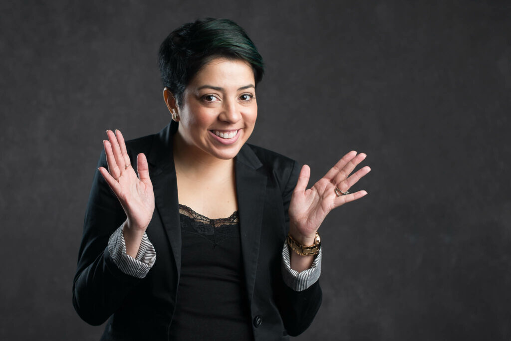 Young professional woman smiling with hand up