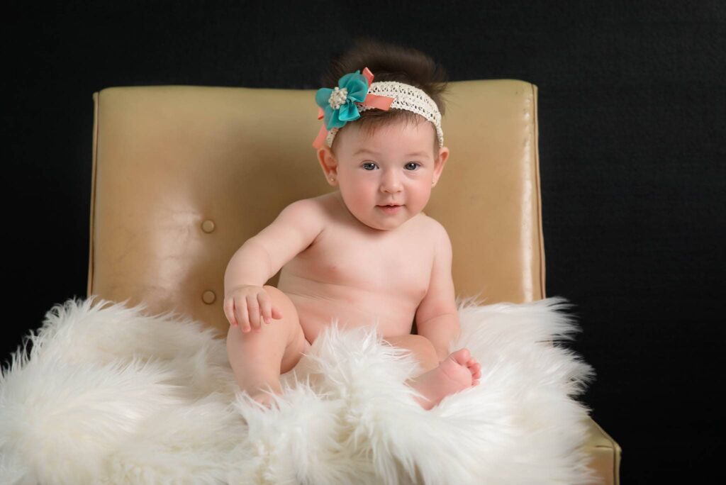 baby girl seating on chair