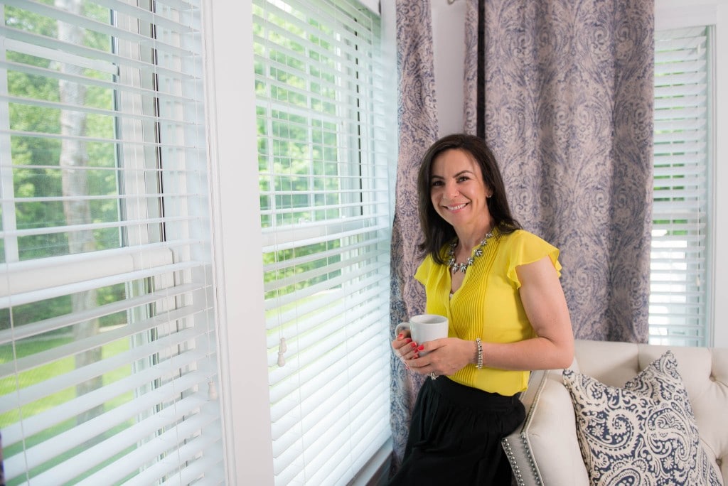 woman holding a cup of coffee by the window