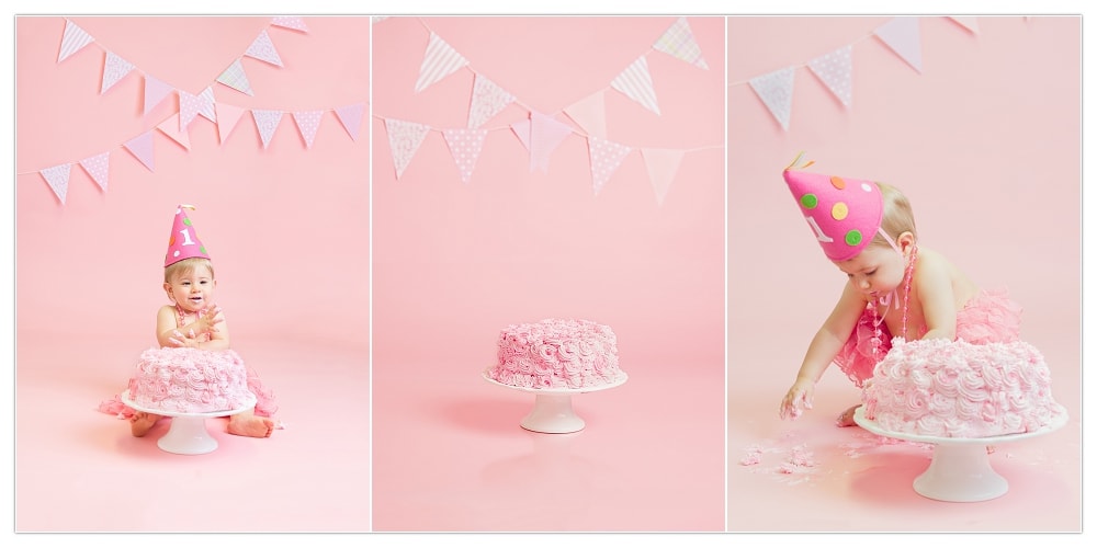 baby girl clapping hands with pink cake