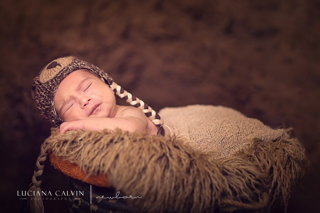newborn baby sleeping on a basket newborn baby making faces while sleeping on a basket