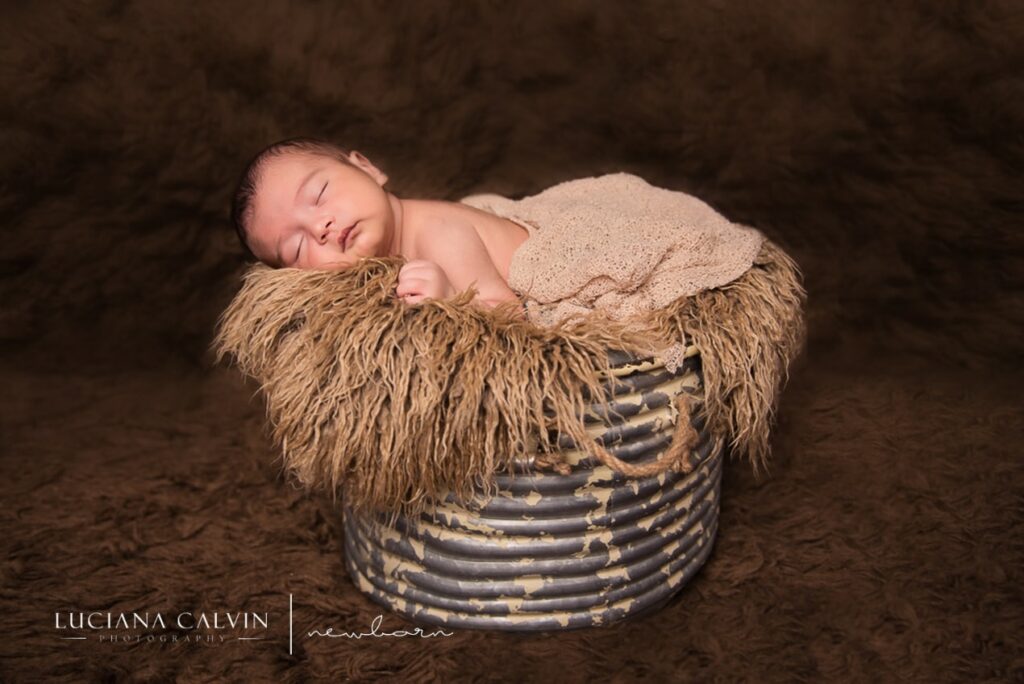 newborn sleeping on a basket on top of fur newborn sleeping on a basket on top of fur