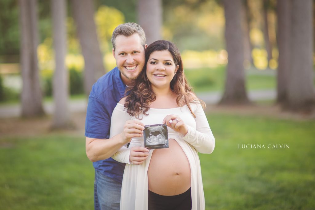 Future parents holding ultrasound pictures