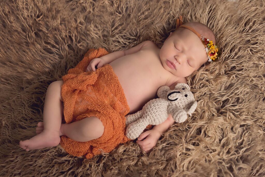 newborn sleeping with a little bear