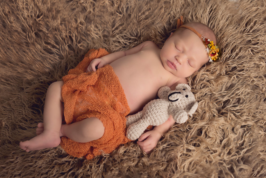 newborn sleeping with a little bear