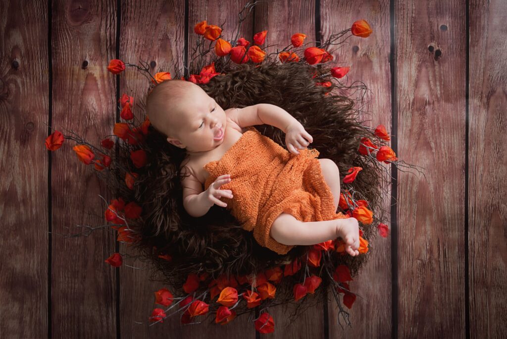 newborn laying in a basket with flowers