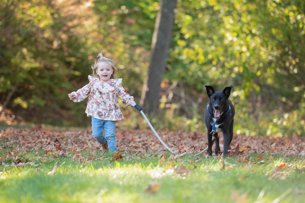 a child running with a dog