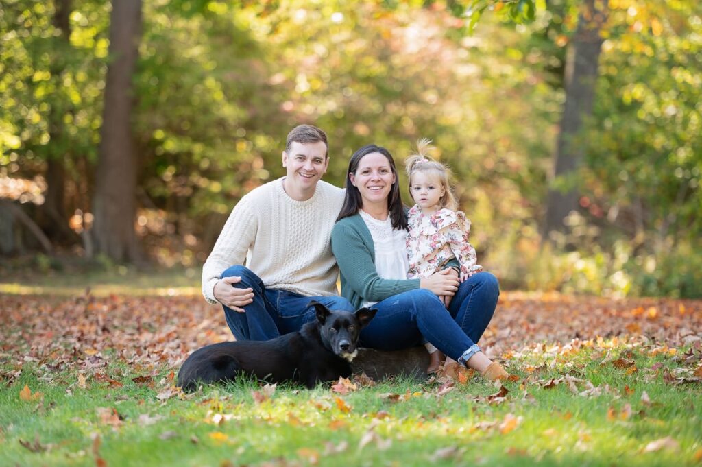 a man and woman with a dog and a child