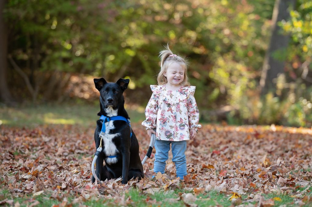 a girl and a dog in leaves