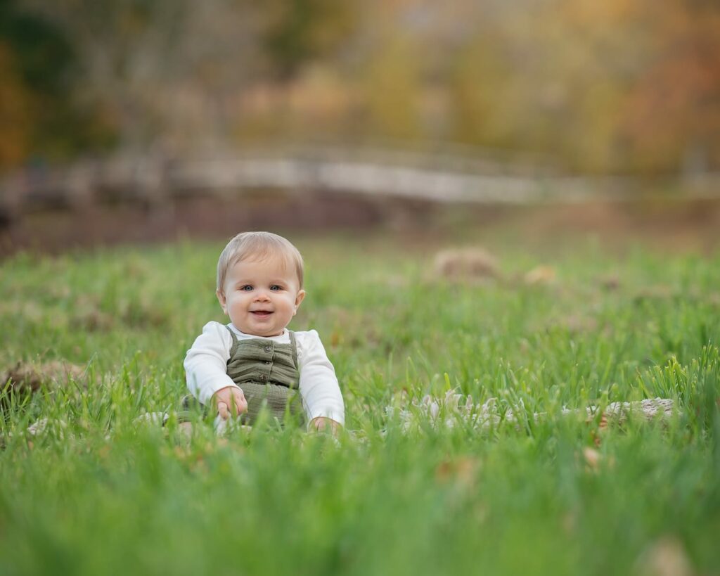 a baby sitting in grass
