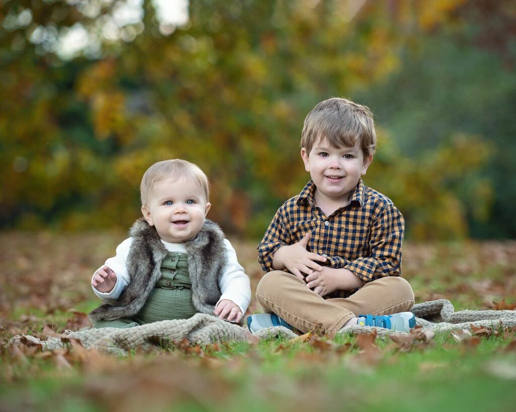 two children sitting on the grass