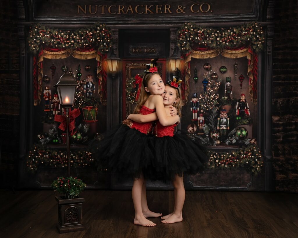two girls in tutu skirts hugging in front of a christmas store